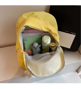 Detailed view of yellow nylon backpack interior capacity with tablet and daily essentials