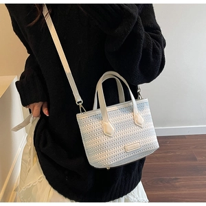 Detail of the blue and white striped knit bucket bag with hollow woven texture and strap