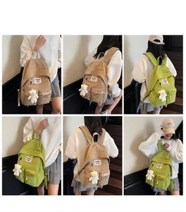 Detail view of large canvas backpack with plush bear charm and double front pockets