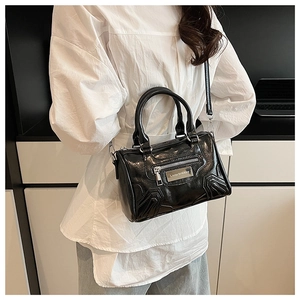 Detalle de bolso Boston negro brillante con placa de metal Lazy Breeze y bandolera