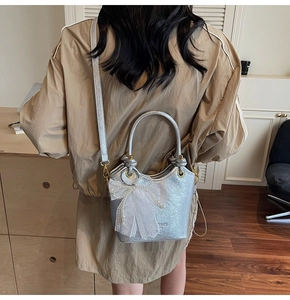 Sac seau argenté avec nœud en dentelle et perle vu de dos porté par un mannequin