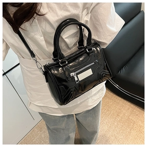 Detalle del bolso Boston negro brillante con la placa de metal plateada Lazy Breeze
