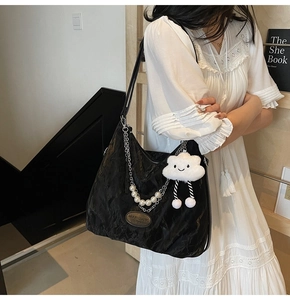 Détail du sac cabas plissé noir avec chaîne en perles et charme nuage en peluche