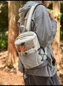 Detailed view of hiking backpack with side mesh pocket and orange zipper accents