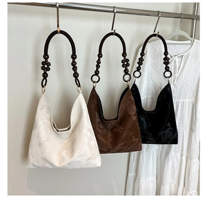 Detail of hobo handbag with marble-textured suede and decorative wooden bead handles