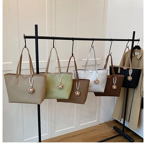 Sacs cabas minimalistes en six coloris avec breloque fleur sur un support métal