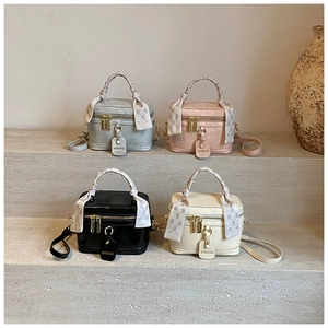 Détail de sacs à main structurés en quatre couleurs avec poignées enroulées de foulards
