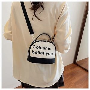Black and white canvas bowling bag with slogan print shown on model in cozy setting