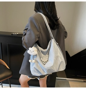 Détail du sac cabas en nylon bleu clair plissé avec chaînes et pendentif nuage