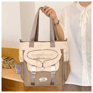 Detail of multi-pocket canvas tote bag with front flap pocket and adjustable buckle