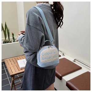 Detail of blue and beige canvas crossbody bag with wide shoulder strap in daily scene