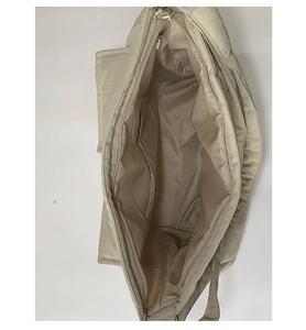 Interior view of beige canvas tote bag showing large capacity with zipper and inner pocket