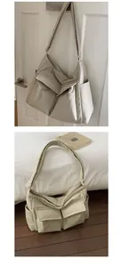 Detail of beige canvas tote bag with dual front pockets and adjustable shoulder straps