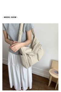 Detail of a beige large capacity canvas tote bag showing dual front pockets and durable material