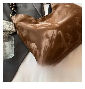 Glossy brown Hobo shoulder bag featuring vintage wooden bead accents on the strap