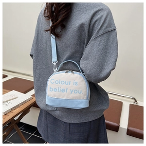 Detail of canvas mini bowling bag with blue accents and adjustable crossbody strap