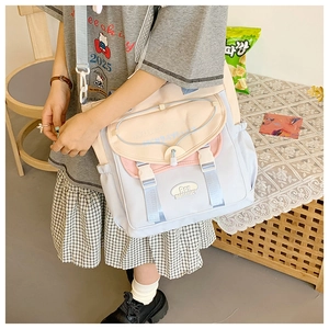 Detail of multi-color canvas messenger bag featuring pastel blue and pink patchwork design