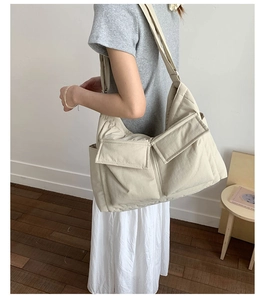 Detail of beige large capacity crossbody canvas bag with double front pocket design