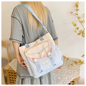 Detail of color-block canvas bag with MONDAYLUCK text and adjustable buckle closure