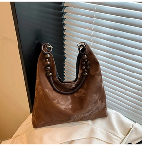 Detail of a brown marble textured tote bag featuring a unique dark wood beaded handle