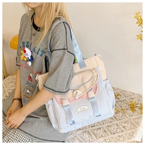 Detail of color-block tote bag with buckle closure and multiple functional pockets