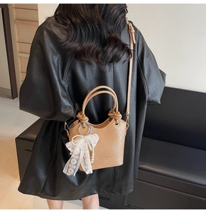 Sac seau marron avec nœud en dentelle et breloque perle sur bandoulière en cuir
