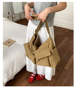 Detail of khaki large capacity canvas messenger bag with functional multi-pocket design