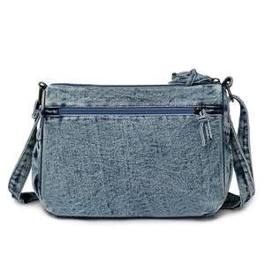 Détail d'un sac en jean bleu clair avec compartiment zippé et tirette en corde tressée