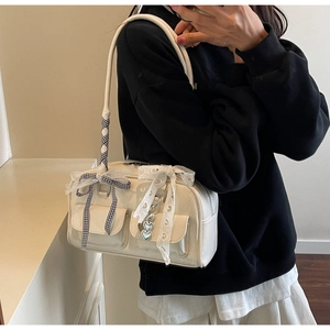 Detail of off-white shoulder bag with checkered bows and metallic heart charm accents