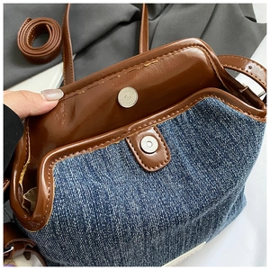Close-up detail of denim and brown leather patchwork bag with silver magnetic buckle