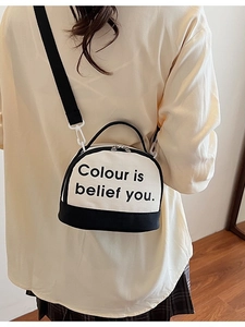 Chic canvas bowling bag with contrast black handles and detachable shoulder strap