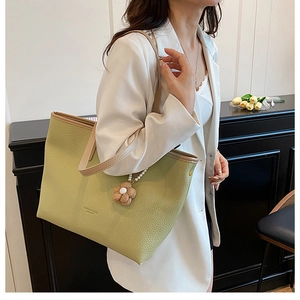 Détail du sac cabas en cuir vert clair avec breloque décorative en perles et fleurs