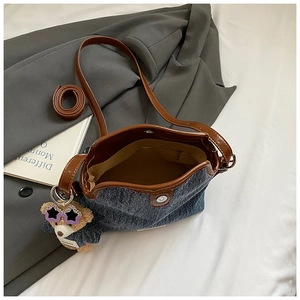 Interior view of denim bucket bag with magnetic closure and cute bear charm detail