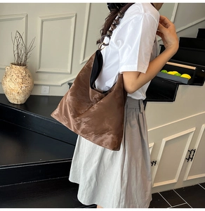 Brown suede tote bag detail featuring a beaded shoulder strap and soft velvet texture