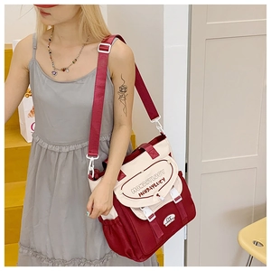 Detail shot of canvas crossbody bag showing contrast colors and adjustable strap design