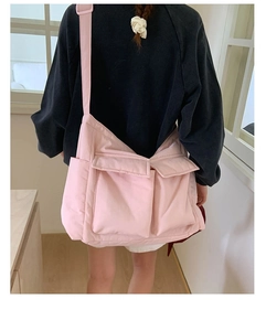 Pink nylon crossbody bag detail with two front pockets and wide shoulder strap