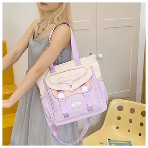 Side view of large color-block tote bag with side pockets and adjustable buckle straps