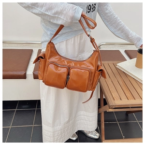 Detail view of retro caramel brown shiny crossbody bag with multiple utility pockets