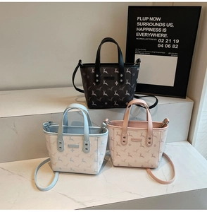 Three mini bucket bags in brown, blue and pink with deer prints on marble stairs