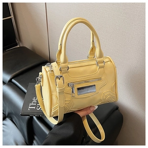 Vista de detalle del bolso Boston amarillo con textura de cuero PU y herrajes plateados