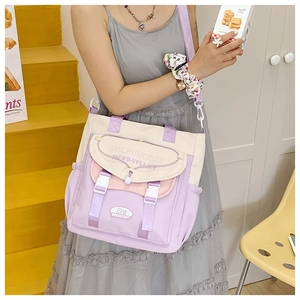 Detail of a color-block canvas crossbody bag with adjustable straps and side pockets