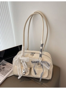 Creamy white Boston shoulder bag with lace bow and heart pendant in a minimalist setting