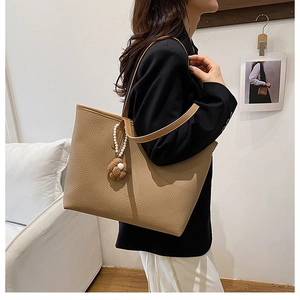 Détail du sac cabas kaki en cuir grainé avec pendentif fleur et perles blanches