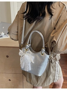 Sac seau en cuir argenté avec éclat métallique, poignée anneau et nœud en dentelle