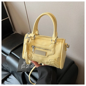 Detalle del mini bolso Boston amarillo brillante con placa metálica de Lazy Breeze