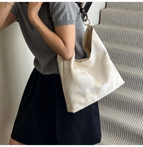 Detail of hobo bag featuring marble patterns and a unique wooden bead shoulder strap