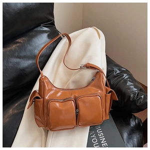 Detailed view of brown glossy PU leather shoulder bag with functional multi-pocket design
