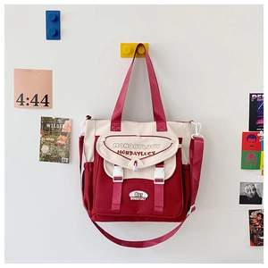 Detail of the red and white canvas tote bag with adjustable buckle and front pocket