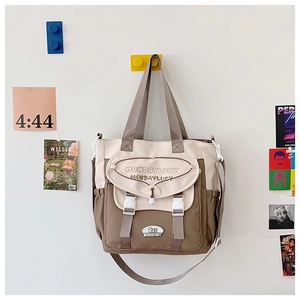 Detail of canvas tote bag showing two-tone stitching, sturdy straps, and buckle closure