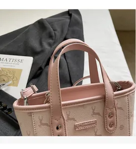 Detail of light pink bucket bag featuring deer pattern and pebbled leather texture